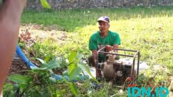 Yadi tengah memasang pompa diesel sedot air di lahan miliknya. Mengambil air dari sumur yang dibuat di pinggiran sawah, 20 September 2024. (Foto: Al Ahmadi/BeritaIDN)