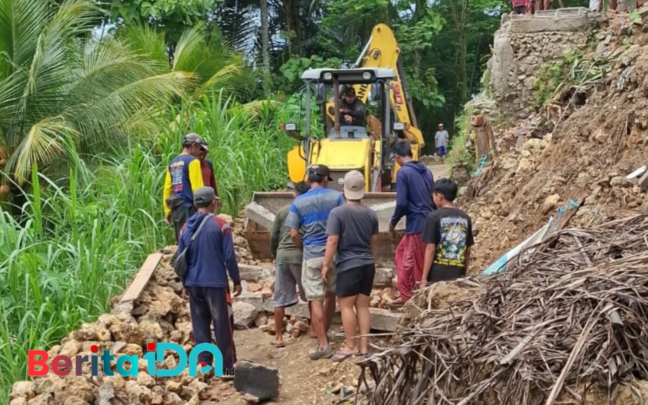 Alat berat diterjunkan untuk mengangkat timbunan longsoran tanah dibantu oleh warga setempat. (Foto: Al Ahmadi/BeritaIDN)