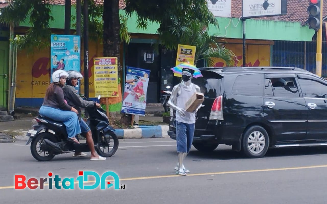 Manusia silver tengah beraksi di Lampu Merah Penceng Pacitan, Minggu, 5 Januari 2025. (Foto: Diki Kurnia/BeritaIDN)