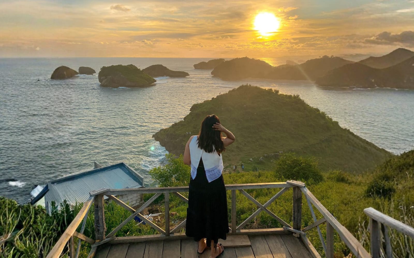Wisatawan tengah menikmati panorama matahari terbenam di Pantai Kasap, Kabupaten Pacitan, dengan latar gugusan karang yang kerap disebut sebagai Raja Ampat-nya Jawa Timur. (Foto: Instagram @jennifertandean)