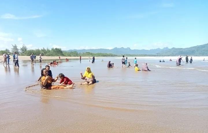 Pengunjung menikmati suasana Pantai Teleng Ria dengan bermain air di tepian pantai, Desa Sidoharjo, Kecamatan Pacitan, Rabu, 15 Oktober 2025. (Foto: Instagram @parai.telengria)